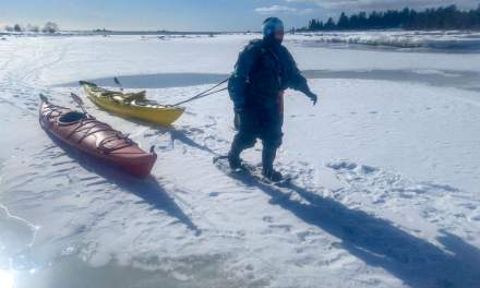Annika on snow shoes pulling back the kayak after the tour.
