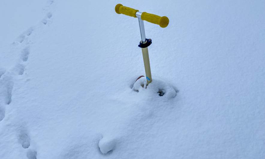A toy scooter in the snow
